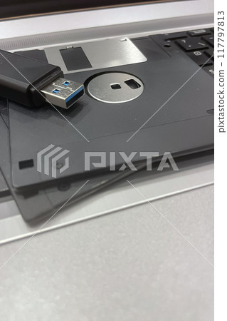 From Past to Present. The Evolution of Data Storage. The striking visual comparison between an old black floppy disk and today's blue USB stick symbolizes the rapid advancement of data storage technol 117797813