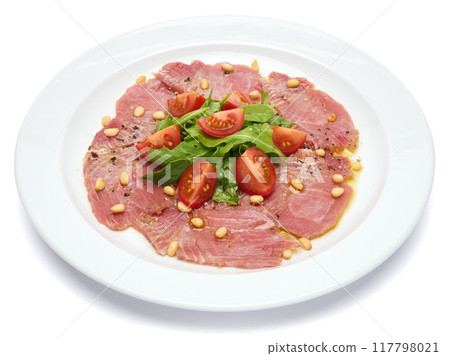 cooking tuna carpaccio - Fresh raw tuna fillet with olive oil and pine nuts on white ceramic plate 117798021