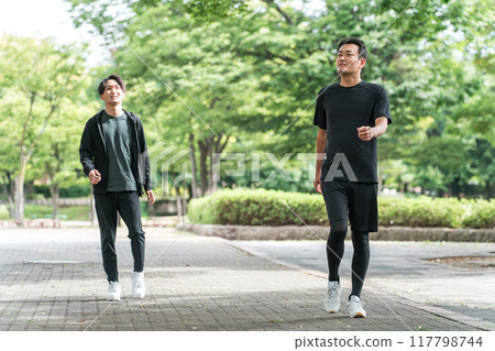 Asian man walking/jogging in a park with fresh greenery 117798744