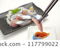 Holding chopsticks for raw saury sashimi 117799022
