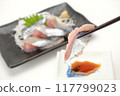 Holding chopsticks for raw saury sashimi 117799023