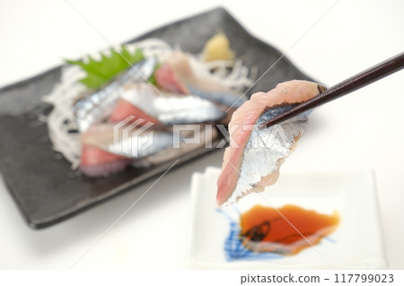Holding chopsticks for raw saury sashimi Holding chopsticks for raw saury sashimi 117799023