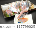 Holding chopsticks for raw saury sashimi 117799025