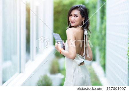beautiful asian freelance Success people business woman fashion model in summer white sleeveless dress using casual working with tablet for browsing internet, chatting and blogging in coffee shop. beautiful asian freelance Success people business woman fashion model in summer white sleeveless dress using casual working with tablet for browsing internet, chatting and blogging in coffee shop. 117801007