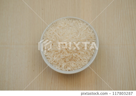 rice in a bowl with wooden background rice in a bowl with wooden background 117803287