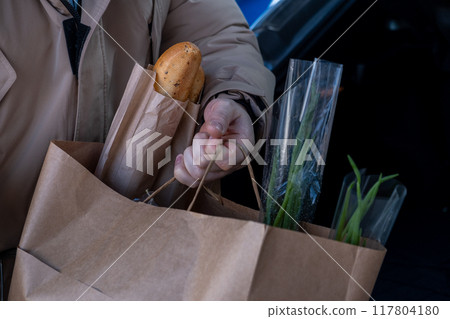 Man Loading Groceries into Car Trunk Man Loading Groceries into Car Trunk 117804180