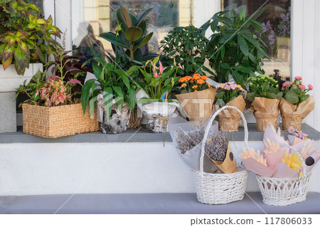 Shop of flowers and bouquets. Sale of flowers and gifts for holidays. Shop window in a city. Floral decoration. 117806033