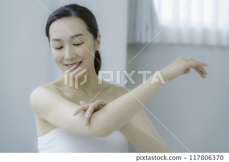 年輕女子在客廳清理手臂 年輕女子在客廳清理手臂 117806370