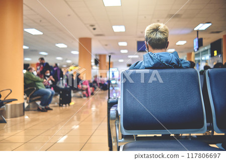 Empty chairs in the departure hall of the airport. Unrecognizable people blurred. 117806697