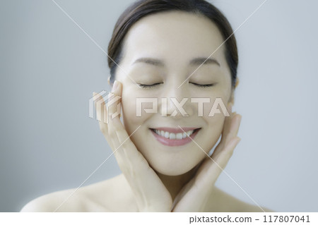Young woman taking care of her facial skin Young woman taking care of her facial skin 117807041