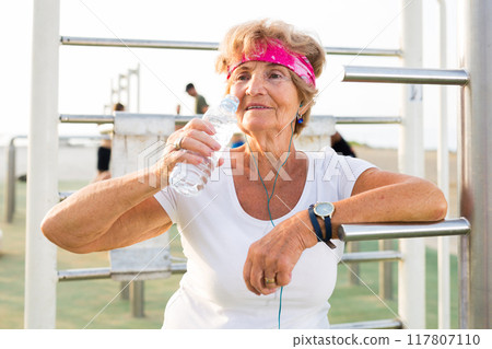 Old lady in outdoor workout station 117807110