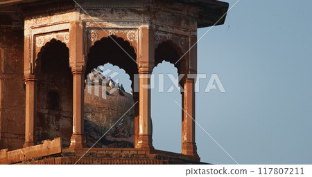 Varanasi, Uttar Pradesh, India. Pigeons Sit On Tower Of Het Singh Fort, Jain Ghat. Clear Blue Sky. . Ancient Fort. Red Wall Of Chet Singh Fort Varanasi, Uttar Pradesh, India. Pigeons Sit On Tower Of Het Singh Fort, Jain Ghat. Clear Blue Sky. . Ancient Fort. Red Wall Of Chet Singh Fort 117807211