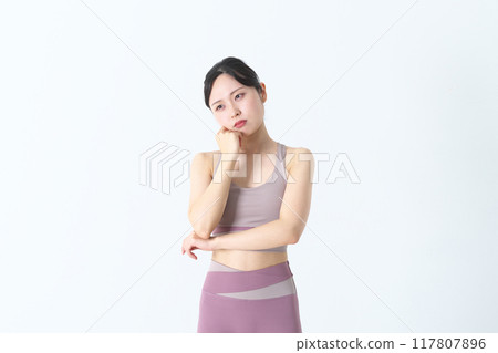 A worried woman in yoga wear A worried woman in yoga wear 117807896