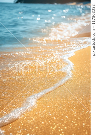 Sparkling Sunlit Beach with Gentle Waves and Golden Sand in a Serene Coastal Setting Sparkling Sunlit Beach with Gentle Waves and Golden Sand in a Serene Coastal Setting 117808358