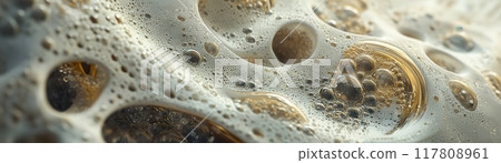 Close-Up of Frothy Bubbles on a Liquid Surface with Golden Hues and Intricate Patterns 117808961