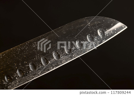 a wet blade of a sharp knife with a wide blade 117809244