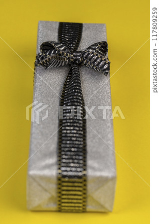 with a black and silver ribbon tied with a silver gift package with a black and silver ribbon tied with a silver gift package 117809259