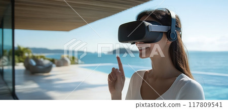 Woman Enjoying Virtual Reality Experience by the Ocean on a Sunny Day 117809541