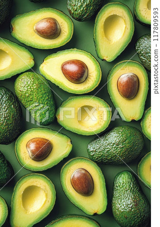 Fresh Avocados Halved and Whole on Green Background - Healthy Food Concept and Organic Produce 117809593