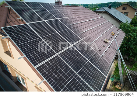 Photovoltaic solar panel fading away and shifting into metal supporting structure. Transition between metal rails and solar modules on roof of house. Concept of alternative energy sources. Aerial view 117809904
