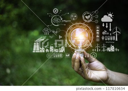 green energy concept help reduce global warming..Hand holding natural background light bulb on green leaf with clean energy icon around it. Carbon dioxide emission in industry zero carbon concept. green energy concept help reduce global warming..Hand holding natural background light bulb on green leaf with clean energy icon around it. Carbon dioxide emission in industry zero carbon concept. 117810634