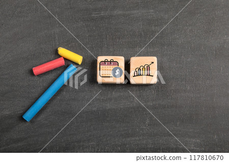 Investment icons. Wooden blocks on a dark chalkboard background 117810670