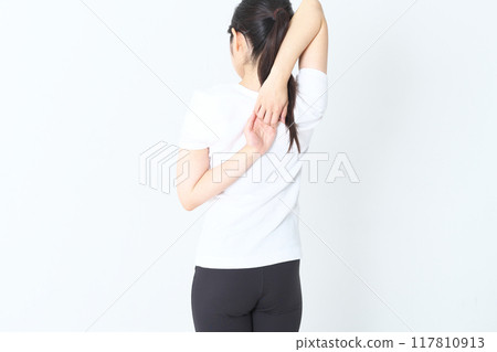 一個20多歲的女人拉伸的後視圖 一個20多歲的女人拉伸的後視圖 117810913