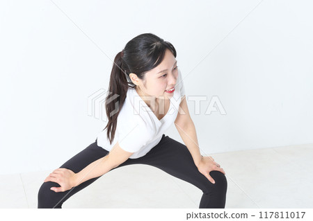 A woman in her twenties stretching 117811017