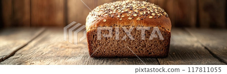 Freshly Baked Whole Grain Bread Loaf on Rustic Wooden Table with Seeds on Top 117811055