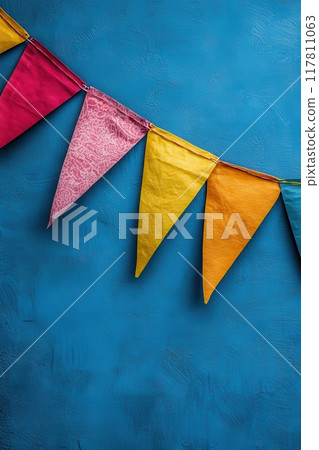 Colorful Pennant Banners Against Blue Textured Wall for Festive Celebrations and Party Decorations 117811063