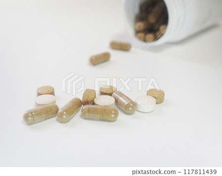 Supplements spilling out of the bottle 117811439