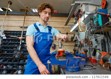 Cropped shot of craftsman using antique bench vise in repair shop Cropped shot of craftsman using antique bench vise in repair shop 117811549
