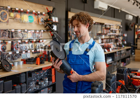 Worker testing big angle grinder at hardware store Worker testing big angle grinder at hardware store 117811570