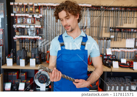 Man worker buying drill consumable tool to make holes in concrete at tools shop Man worker buying drill consumable tool to make holes in concrete at tools shop 117811571