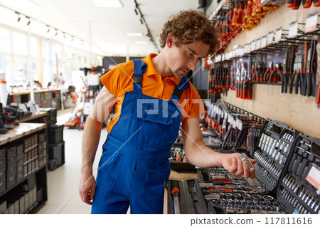 Salesman checking socket wrenches in tool box at hardware store Salesman checking socket wrenches in tool box at hardware store 117811616