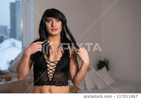 Gay man in wig and black lace lingerie. Gay man in wig and black lace lingerie. 117811867