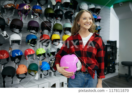 Beautiful young woman holding new pink protective bike helmet 117811870