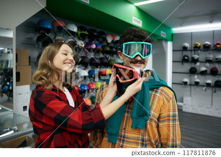 Man and woman couple choosing protective face goggles mask at spots shop 117811876