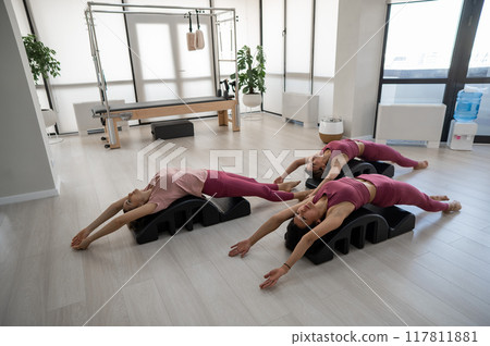 Balanced Body Pilates Arc. Three asian women exercising on pilates arc. Balanced Body Pilates Arc. Three asian women exercising on pilates arc. 117811881