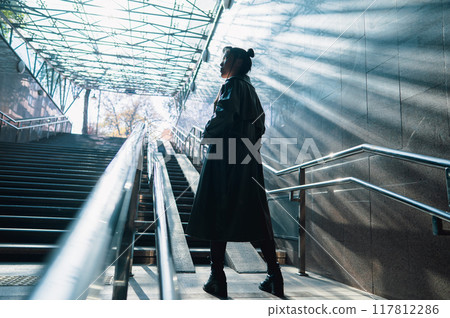 Portrait of a young Asian woman posing in the subway near the stairs. Portrait of a young Asian woman posing in the subway near the stairs. 117812286