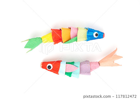 Fish-shaped figures made from recycled paper, egg box cardboard, set against white background. Simple creative craft for kids, representing marine life. DIY, educational, artistic. 117812472