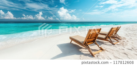 Tropical Beach with Wooden Lounge Chairs and Turquoise Ocean Under a Blue Sky with White Clouds Tropical Beach with Wooden Lounge Chairs and Turquoise Ocean Under a Blue Sky with White Clouds 117812608