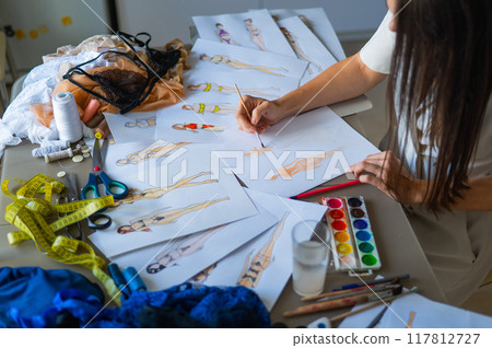 Woman drawing sketches of swimwear and underwear in watercolor.  117812727