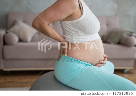 Caucasian pregnant woman suffers from belly pain. Fitball training during pregnancy. Caucasian pregnant woman suffers from belly pain. Fitball training during pregnancy. 117812950