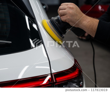 Process of polishing white car body surface using orbital polishing machine.  Process of polishing white car body surface using orbital polishing machine.  117813019