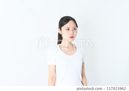 A woman in her twenties standing with a straight face A woman in her twenties standing with a straight face 117813962