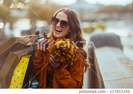 smiling modern 40 years old woman in orange trench coat smiling modern 40 years old woman in orange trench coat 117815248