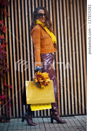 Full length portrait of smiling woman in trench coat 117815261
