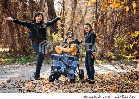 Mother and children in autumn, special needs care, emotional support, family bonding, therapeutic nature, inclusive outdoor activities, disability awareness. Mother and children in autumn, special needs care, emotional support, family bonding, therapeutic nature, inclusive outdoor activities, disability awareness. 117815386