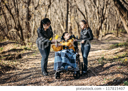Mother and child with special needs on forest walk, nature therapy, disability inclusion, family bonding, outdoor activities, adaptive equipment. Mother and child with special needs on forest walk, nature therapy, disability inclusion, family bonding, outdoor activities, adaptive equipment. 117815407